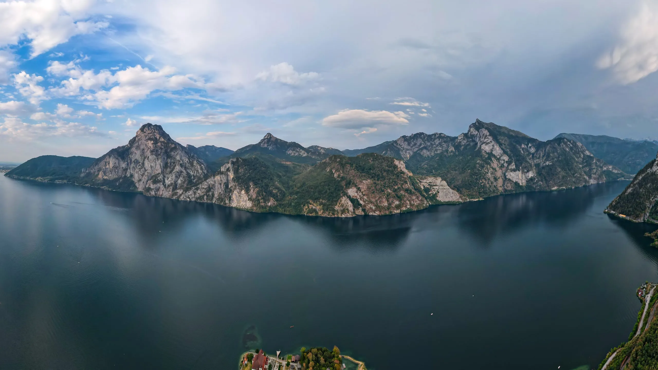 Tmavé jezero Traunsee pod skalnatým hřebenem
